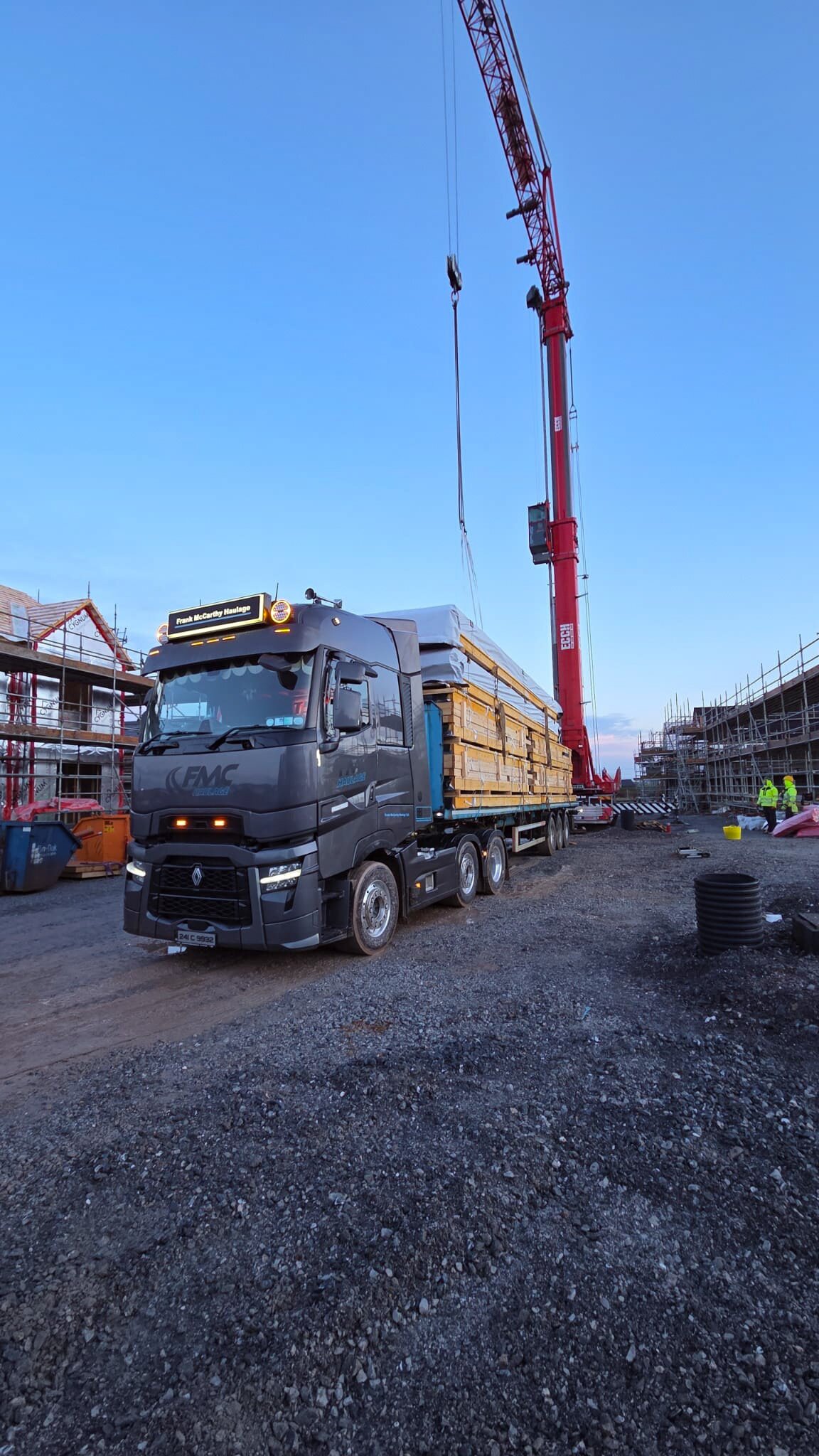FMC Haulage Renault delivering structural timber to a residential construction site at blue hour