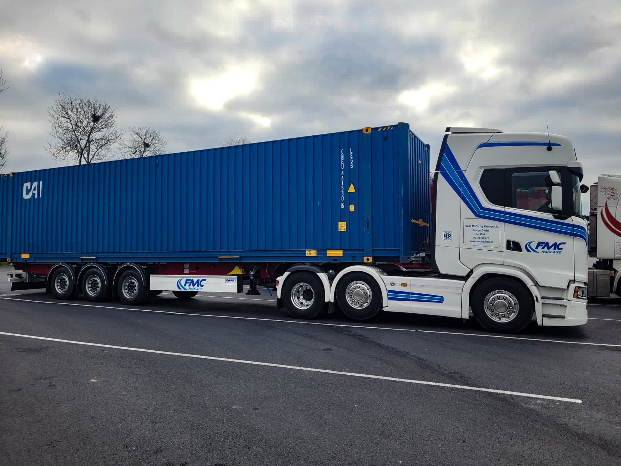 FMC Scania pulling skeletal trailer with 40ft blue container
